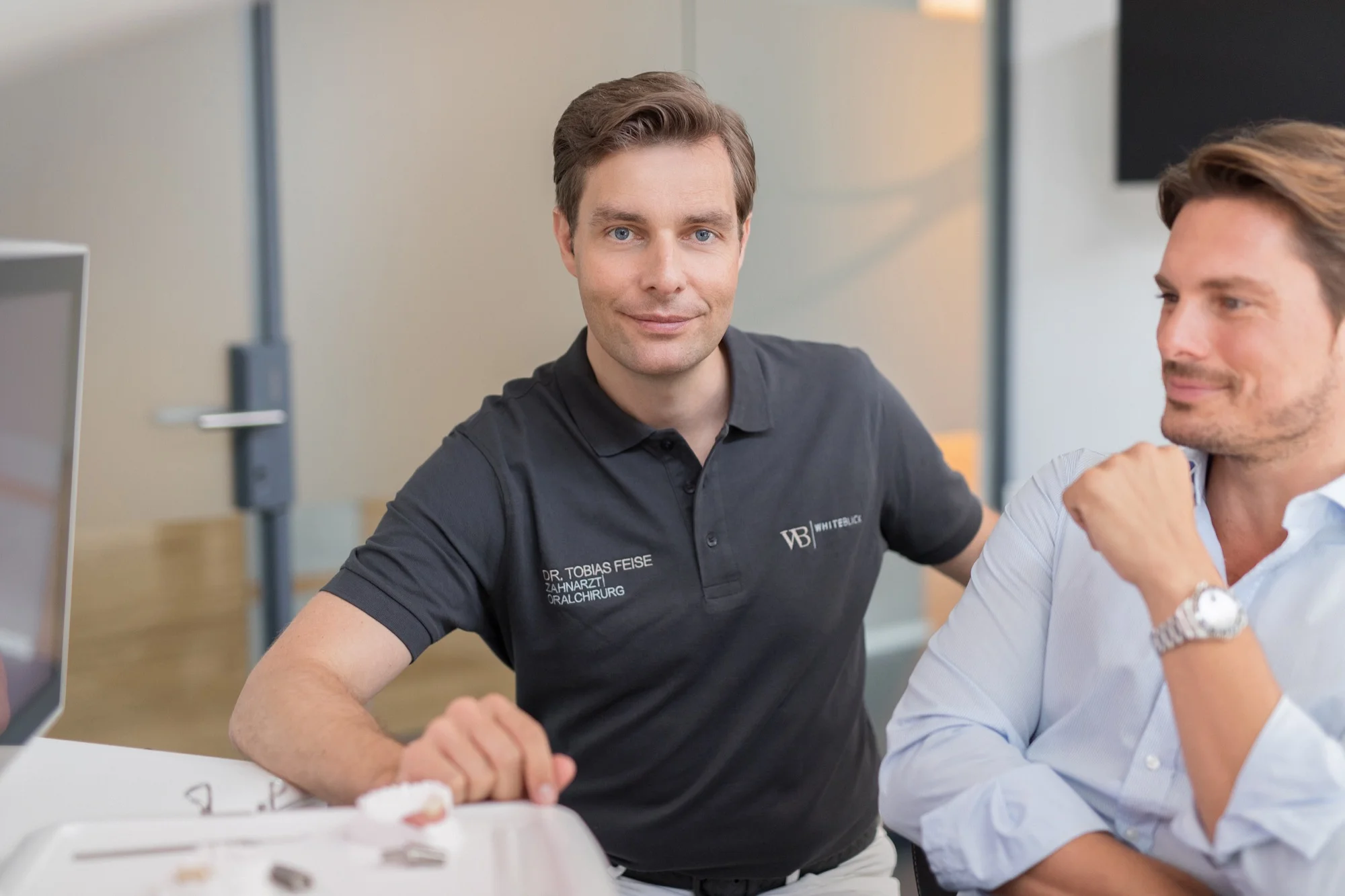 Dr. Tobias Feise, Fachzahnarzt für Oralchirurgie, berät einen Patienten zu Zahnimplantaten.