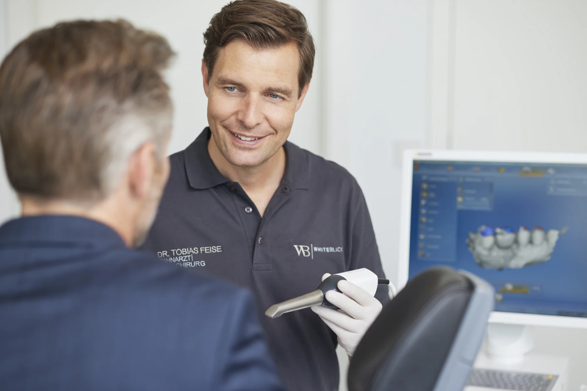 Dr. Tobias Feise berät einen Patienten zum CEREC-System.