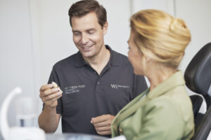 Dr. Tobias Feise, Fachzahnarzt für Oralchirurgie und Implantologie in Stuttgart, berät eine Patientin zu Zahnimplantaten.